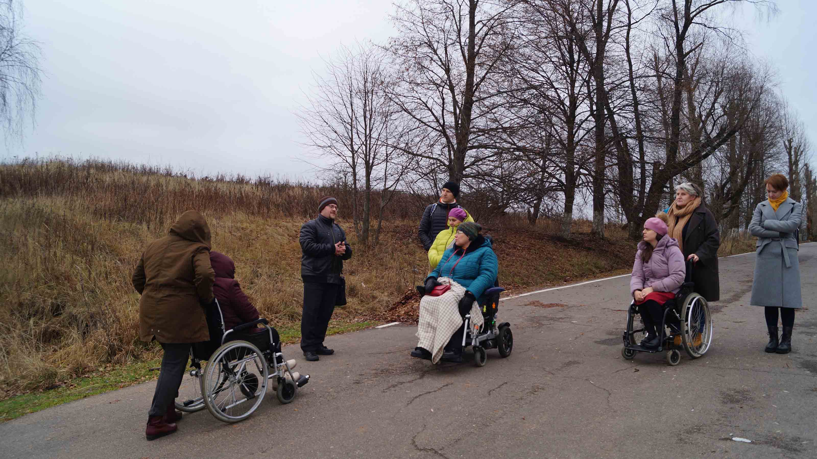 People on wheelchair talking outdoors